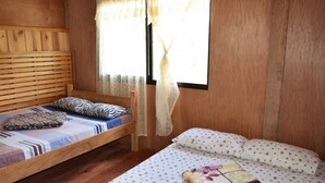A wooden bunk bed with a patterned pillow and a quilted blanket.