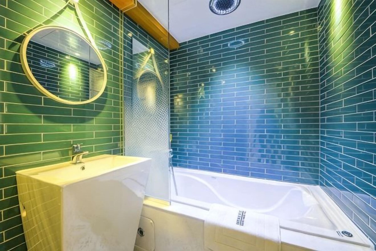 A bathroom with a bathtub, a sink, and a mirror.