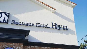 Experience the charm of Boutique Hotel Ryn, featuring a drive-in service and a unique brick facade with a distinctive entrance.