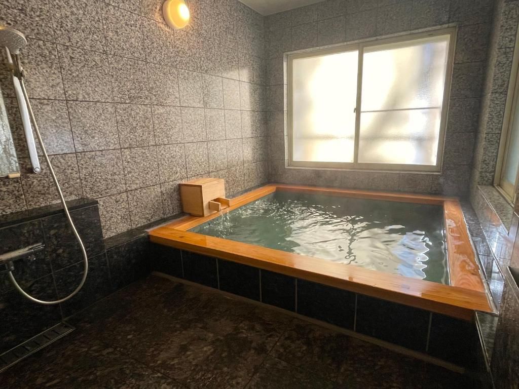 Ein Badezimmer mit Whirlpool, Dusche und Fenster.