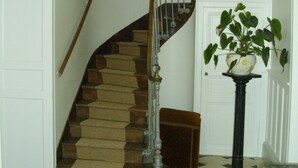 A staircase with a wooden handrail and a black base, leading to a door. - Chambre d'hôtes - Domaine De Berthegille (Sablonceaux)