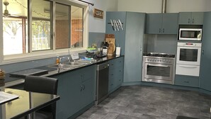 A modern kitchen with grey cabinets, a built-in oven, and a microwave. - Warwick Country Retreat Pets allowed  (Rosenthal Heights)