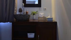 A bathroom with a dark wooden vanity, a large mirror, and a vessel sink. - Wanagiri Cosmic Nature Villa (Wanagiri)
