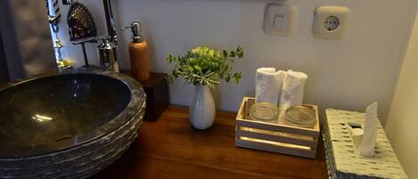 A bathroom with a large vessel sink, a mirror, a ceiling fan, and a wooden vanity.