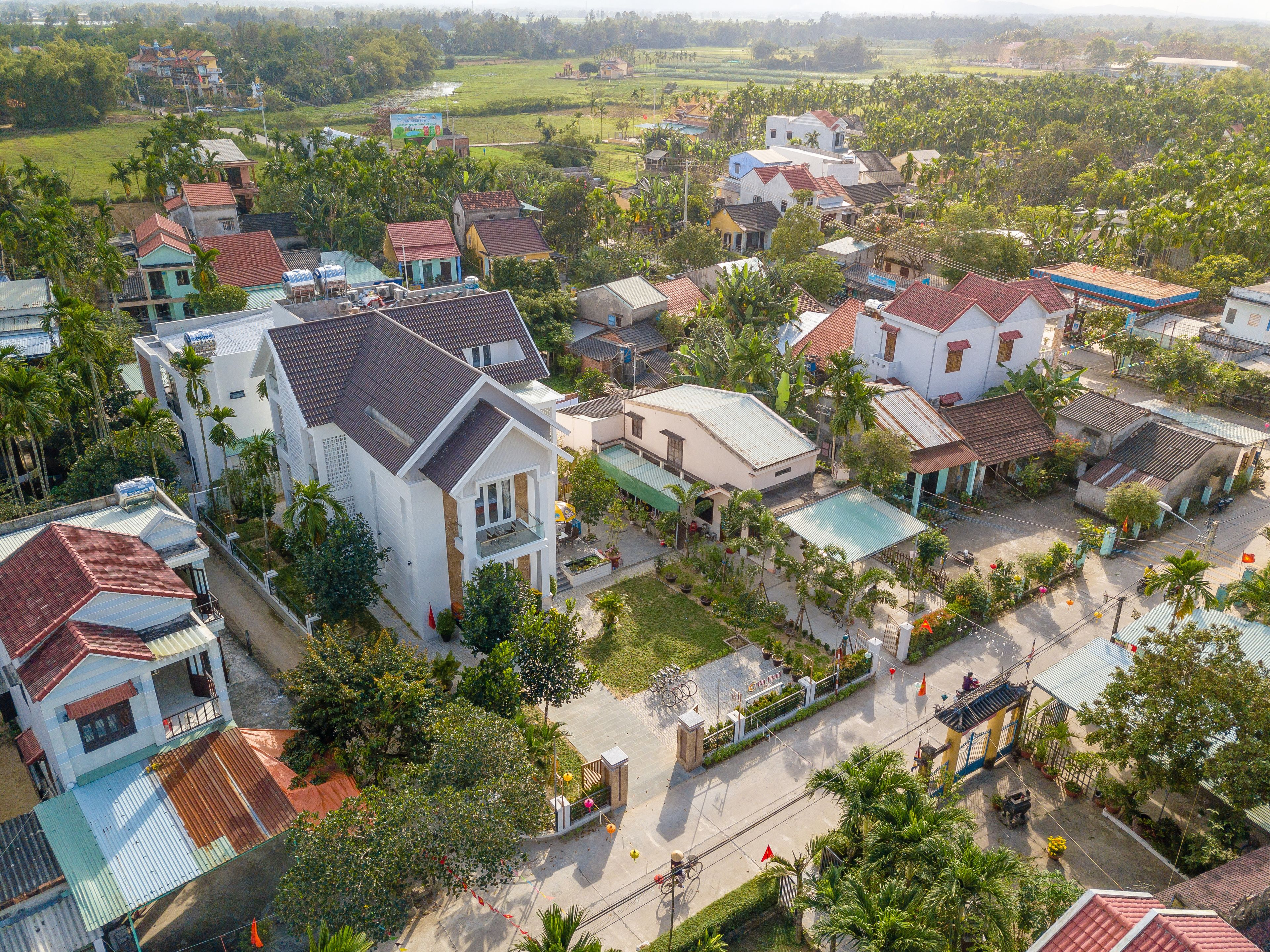 An aerial view of a residential area with houses, roads, and greenery.