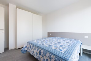 Een slaapkamer met een bed, een kledingkast en een bankje.