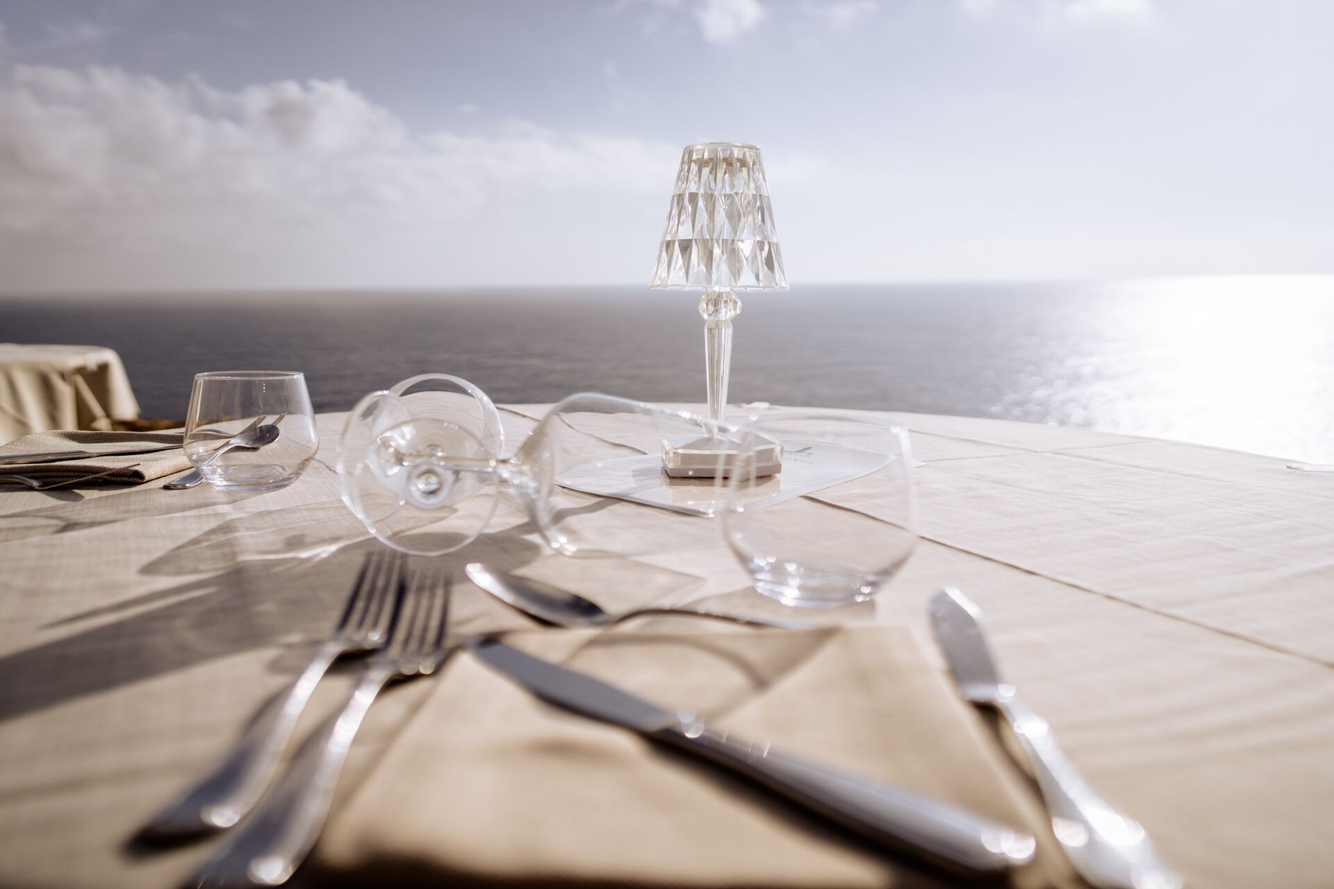 A table set for dining with a view of the sea.