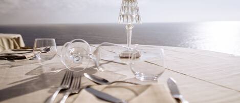 A table set for dining with a view of the sea.
