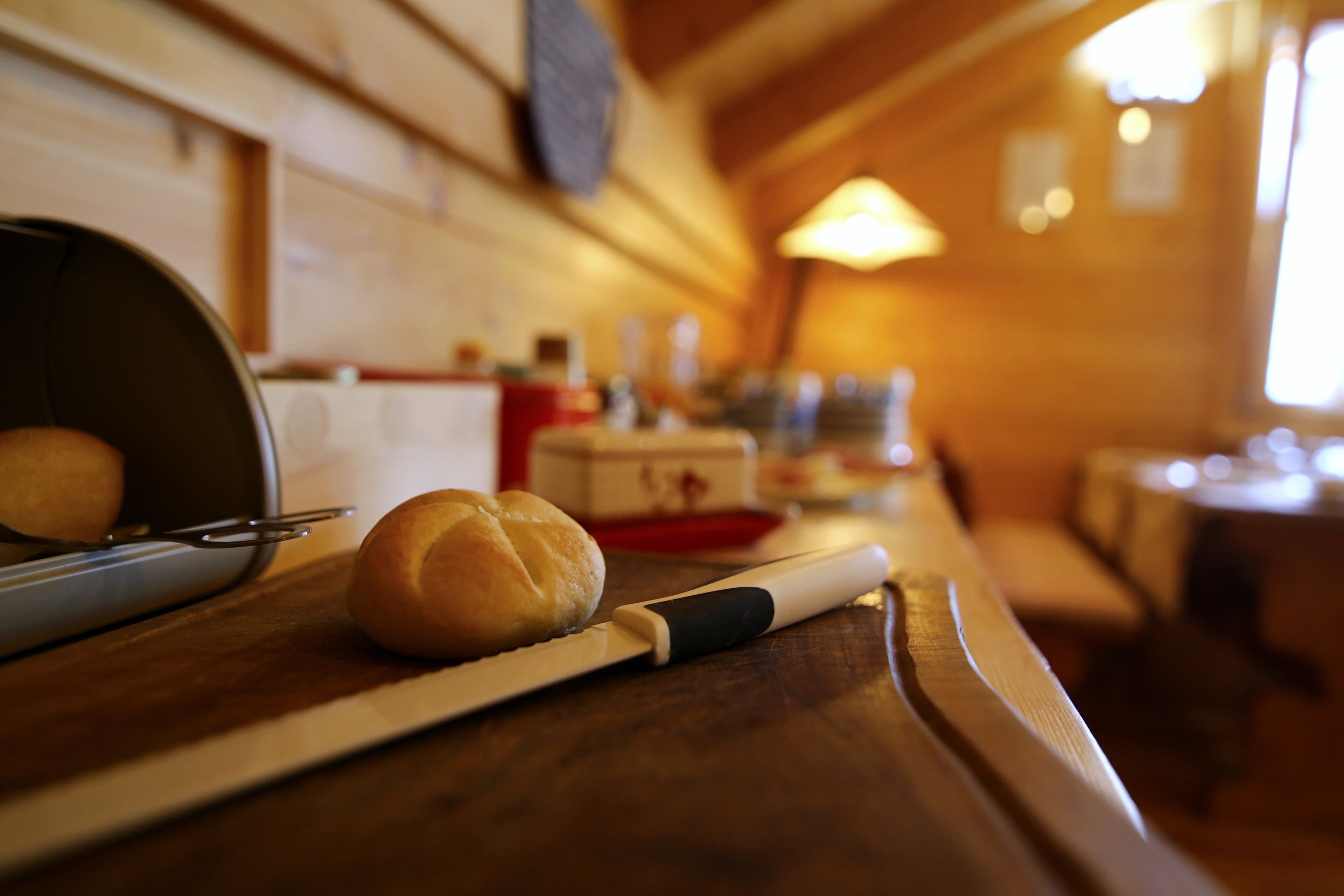 Eine Küchenarbeitsplatte mit einem Brot, einem Nudelholz und einer Brotdose.