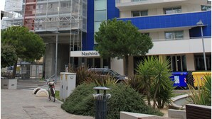 A multi-story building with a blue facade, a sign for 'Nashira apartments', and a construction scaffold on the left side. - Appartamenti Nashira (Lignano Sabbiadoro)
