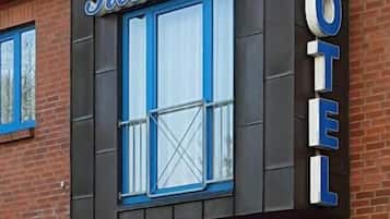 A hotel named 'Residence' with a modern facade, large windows, and a prominent 'HOTEL' sign.
