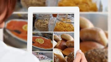 Una persona sostiene una tableta que muestra diferentes alimentos.