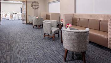 A conference room with a carpeted floor, a sofa, and two chairs.
