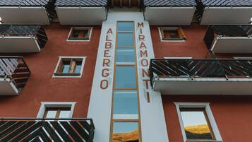 Un edificio con balcones y ventanas, con la inscripción "ALBERGO MIRAMONTI" en la fachada.