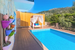 Piscine extérieure, parasols de plage, chaises longues