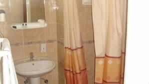 Een badkamer met een wastafel, spiegel en douchegordijn.