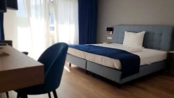 Une chambre d’hôtel avec un lit, un bureau et une chaise.