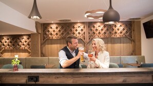 A bar area with wooden paneling, a counter, and seating.