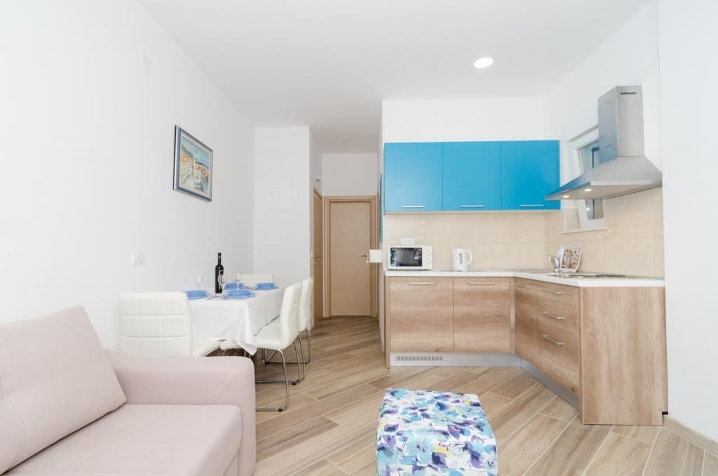 A compact living space with a kitchenette, a dining area, and a sofa.