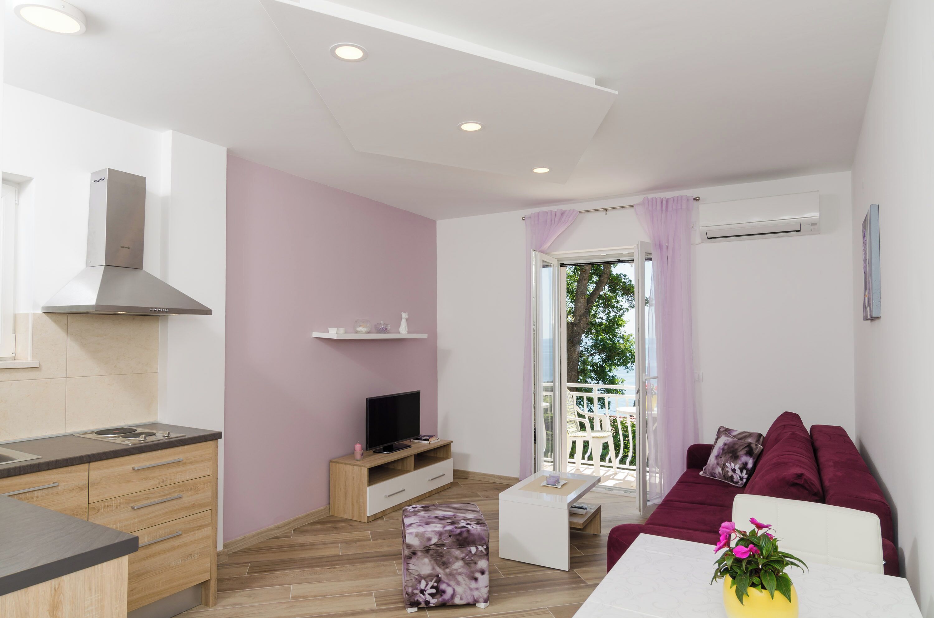 A modern apartment with a kitchen, living area, and balcony.