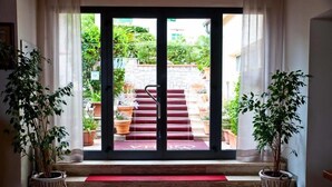 A hotel entrance with a red carpet leading to a set of stairs. - Hotel La Stella (Campo nell'Elba)