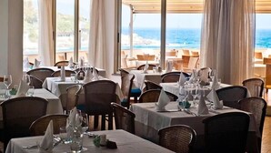 A restaurant with tables set for dining, overlooking a beach. - Hotel La Stella (Campo nell'Elba)