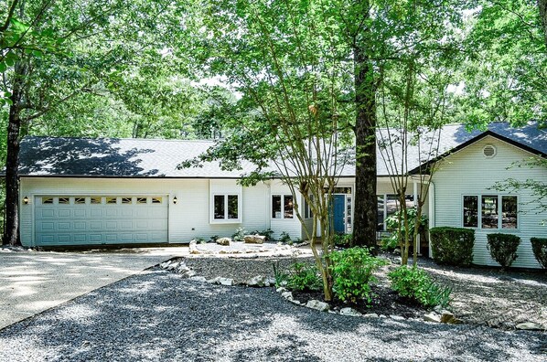 A two-story house with a garage, a front porch, and a driveway.