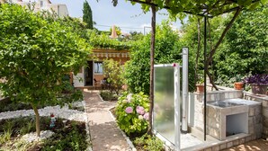 A garden with a pathway, a water feature, and a stone sink. - Apartments Bibijana (Zupa dubrovacka)