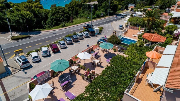 A coastal hotel with outdoor seating, a swimming pool, and a view of the sea. - Apartments Bibijana (Zupa dubrovacka)