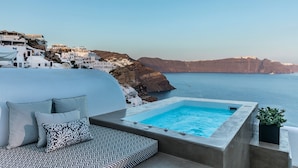 A rooftop terrace with a pool, white buildings, and a view of the sea. - 3 Caves Villa by Caldera Houses (Santorini)
