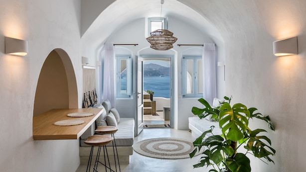 A modern interior with a dining area, seating, and a view of the sea. - 3 Caves Villa by Caldera Houses (Santorini)