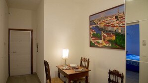 A dining area with a table, chairs, and a painting of a cityscape on the wall. - Nonna Lina Rooms (Florence)