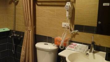 A bathroom with a toilet, sink, and shower.