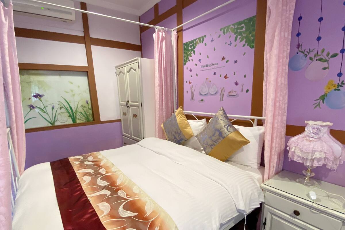 Un dormitorio con cama, mesita de noche, armario y un adorno en la pared.