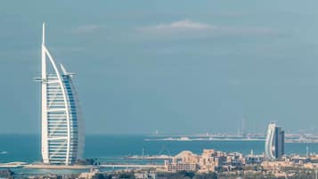 Paisatge urbà costaner amb un edifici prominent i corbat, probablement un hotel, a prop del mar.