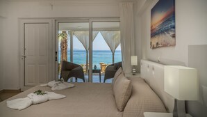 A hotel room with a bed, a nightstand, a lamp, and a painting of a beach scene. - Playa Del Zante (Zakynthos)