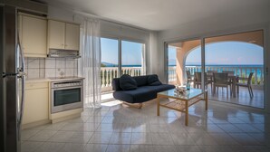 A modern kitchen with a built-in oven and a dining area with a sofa and table. - Playa Del Zante (Zakynthos)