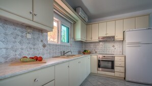 A modern kitchen with light-colored cabinets, a stainless steel oven, and a built-in microwave. - Playa Del Zante (Zakynthos)