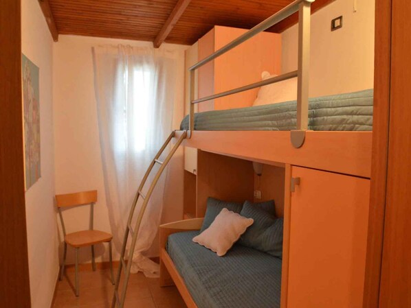 A small, compact room with a bunk bed, a chair, and a ladder. - Villaggio Gabbiano Beach (Vieste)