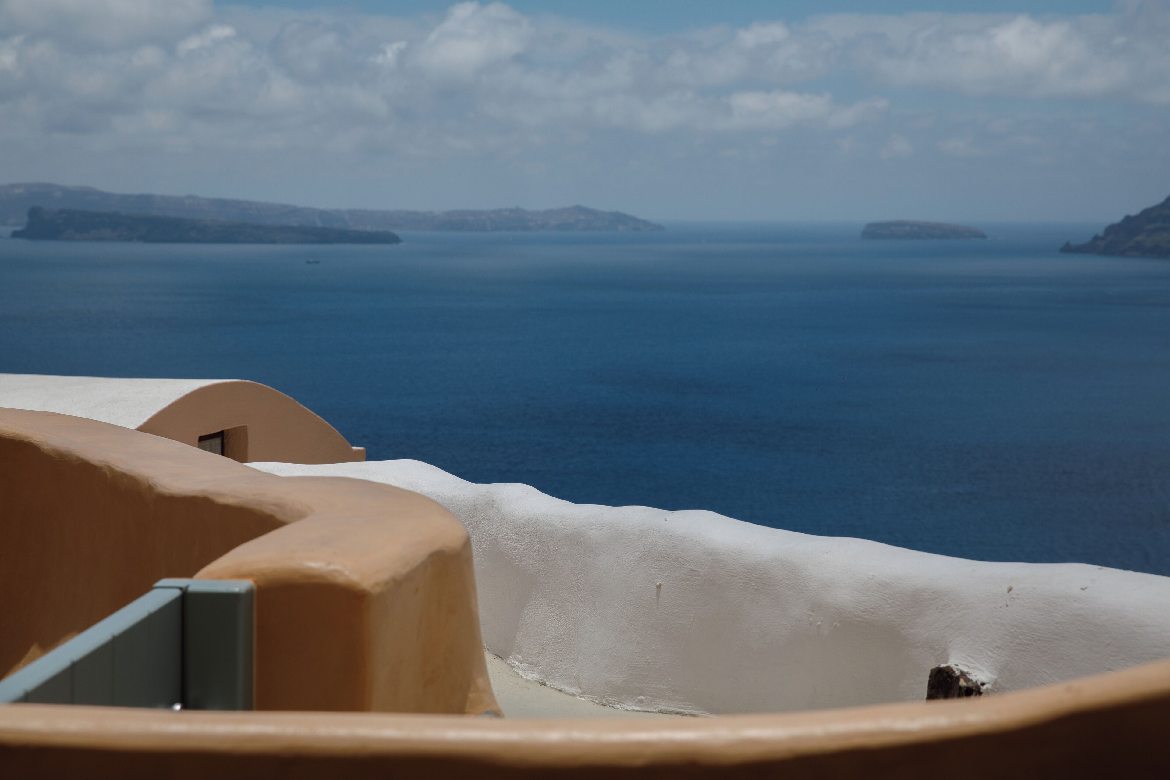 A coastal view with a clear sky, a calm sea, and distant landforms.