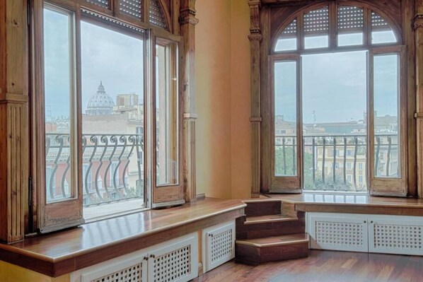 Enjoy the city view from the bay window, featuring a traditional bench and wooden flooring.