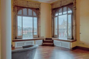Enjoy city views from the large windows, featuring a bench for seating and a radiator below.