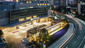 A high-rise hotel with a prominent "Pullman" sign, featuring a modern design with multiple floors and a well-lit entrance. - Pullman Shanghai Qingpu Excellence (Shanghai)
