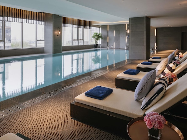 A modern indoor pool area with lounge chairs, a clear pool, and large windows. - Pullman Shanghai Qingpu Excellence (Shanghai)