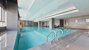A modern indoor swimming pool with clear water, metal handrails, and a tiled floor. - Pullman Shanghai Qingpu Excellence (Shanghai)