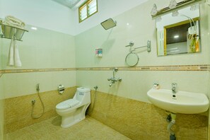 A bathroom with a toilet, sink, shower, and a mirror. - OYO 19587 Chembil Residency (Ambalapuzha)