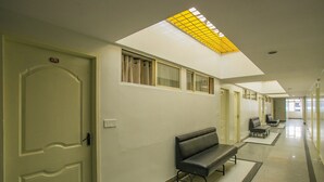 Un pasillo de hotel con tragaluces, bancos y una puerta marcada con el número 430.