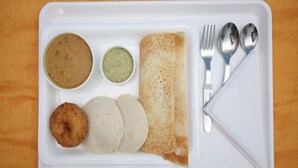 A white tray with a crepe, two round flatbreads, a bowl of soup, and a bowl of green chutney. - Capital O 18946 Admire Suit Hospitality (Chennai)
