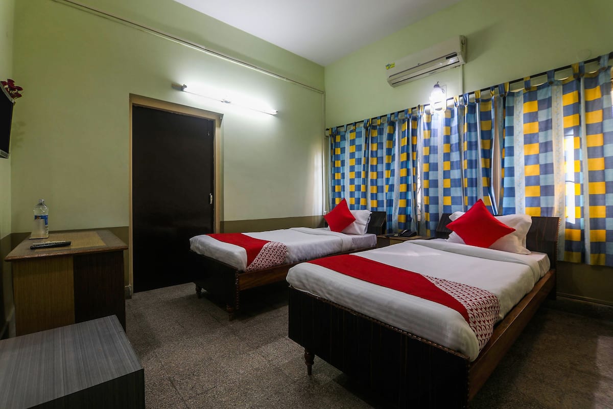Une chambre d’hôtel avec deux lits, un bureau et une porte.
