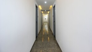 A long, narrow hallway with white walls and a polished floor.